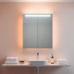 Showcase a stylish led bathroom mirror Cabinet illuminating a modern bathroom setup.
